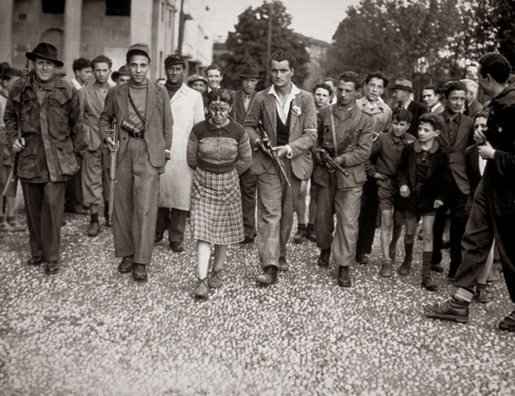 A young teenage girl found guilty of having a relationship with a German officer is led to a public shaming in a town after already being marked in France, 1944.