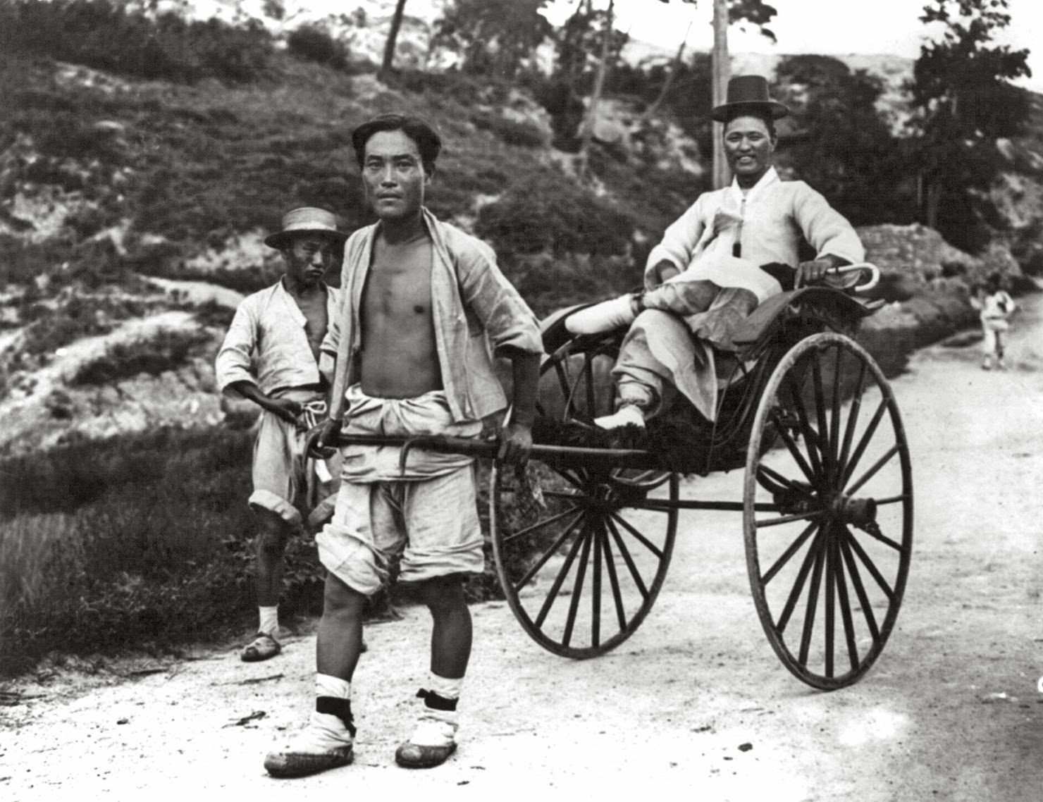 A man is pulled by his servant in Korea, 1910.