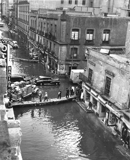 People continue their daily lives even after the city streets have flooded in Mexico City, Mexico in 1951.
