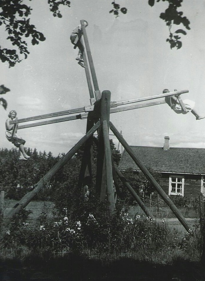 A family plays on a unique four person homemade swing in Finland, 1954.