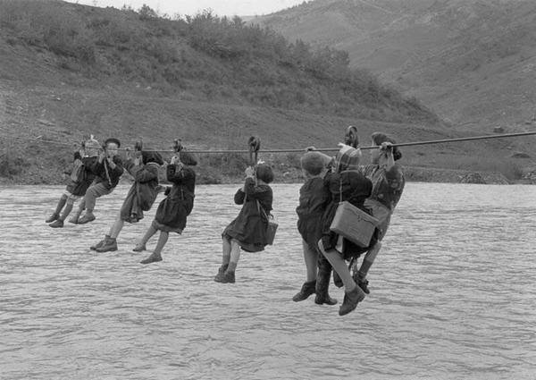 Children cross the river using pulleys on their way to school in the outskirts of Modena, Italy, 1959.