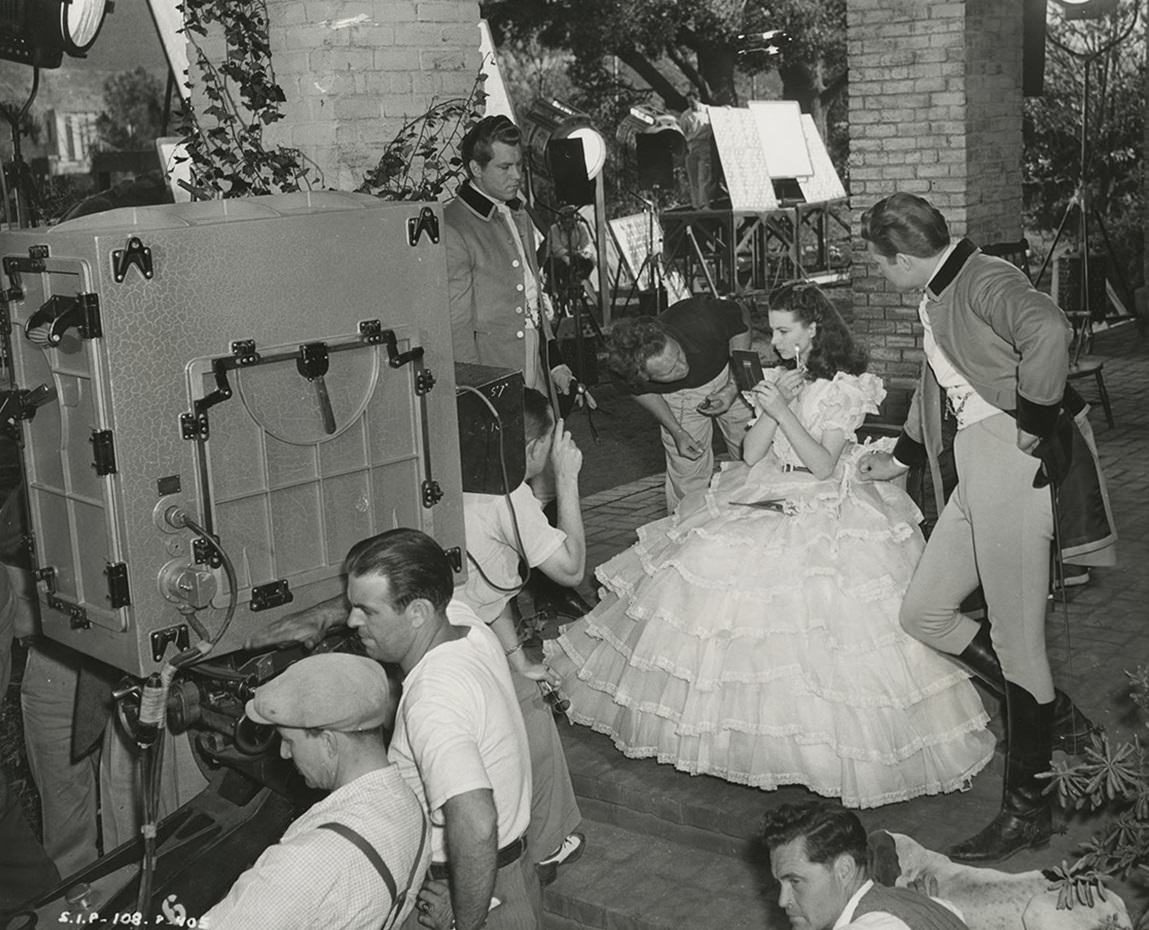 Vivien Leigh touches up her make up as Fred Crane and George Reeves prepare to film a scene of Gone With the Wind in 1939.