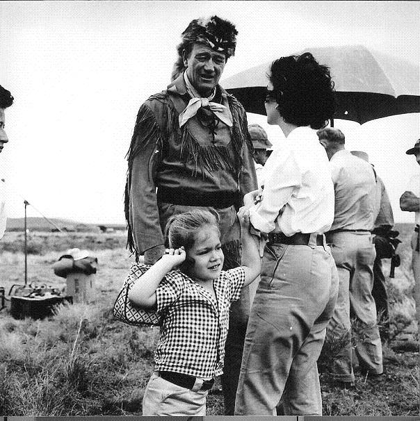 John Wayne takes a break to talk with his wife Pilar Wayne and his daughter Aisse Wayne while filming The Alamo in 1960.