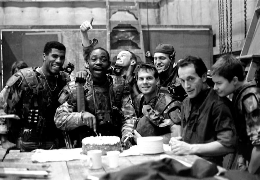 The entire cast of Aliens celebrating Al Mathews birthday after a difficult day of shooting. Mathews said of this moment- "My fondest memory on Aliens was this: We were trying to get my whole squad into the APC as quickly as possible. Man, we must have done ten takes, on the very last take, we got it right. Once we were all in, in a military manner, we had the take in the can. Suddenly the door opened and I shouted, ‘What the fuck is going on?’ I was tired and I knew the opening of the door would screw the sound and we would have to go again. I turned towards the door with smoke coming from my nostrils. There was Miss Weaver holding the biggest birthday cake I had ever seen in my life, and wearing the warmest smile ever! The whole cast and crew knew it was my birthday, and they were all in on it. I was so embarrassed, I broke down and cried. There was Sgt. Apone, bawling like a baby.”