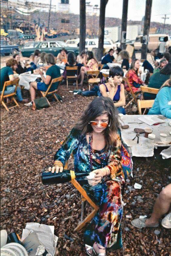 Janis Joplin pouring herself a drink before going on stage at Woodstock, 1969.