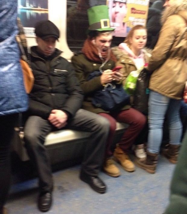 Man with leprechaun hat on train 