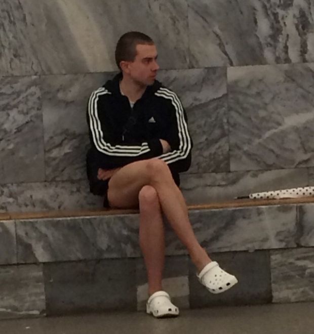 Man in adidas and white crocs waiting for the train