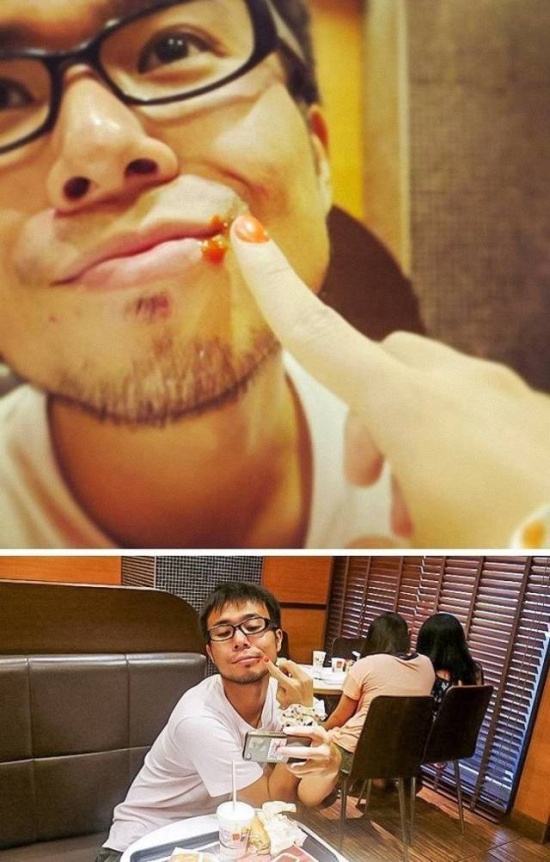Guy with a girl wiping face. Guy taking selfie in fast food restaurant.