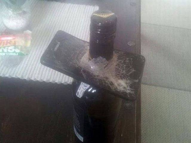 phone crushed onto a bottle