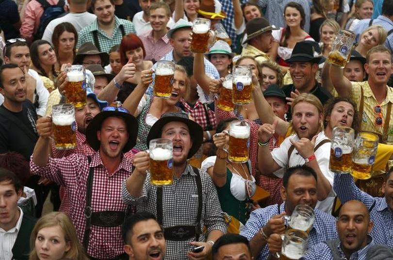A group of people raising a glass of beer for Oktoberfest
