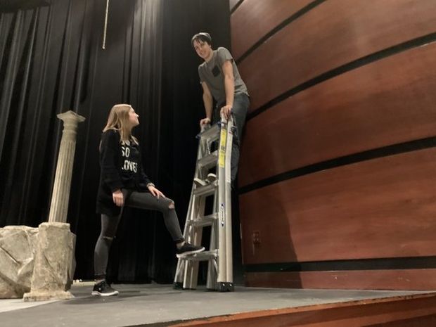 man balancing on a ladder