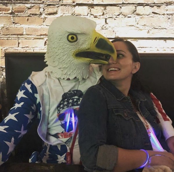 Only in America - man wearing a eagle costume near a girl