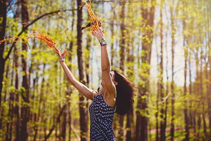 woman throwing spaghetti in a forest - .
