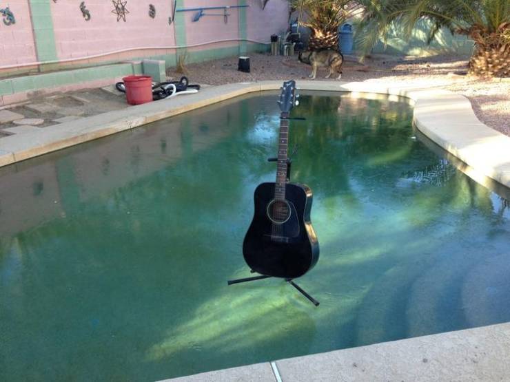 cool winter pics - guitar standing on top of frozen swimming pool