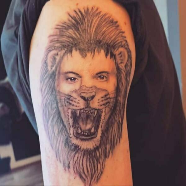 A lion tattoo that looks like an incomplete Animorphs transformation.