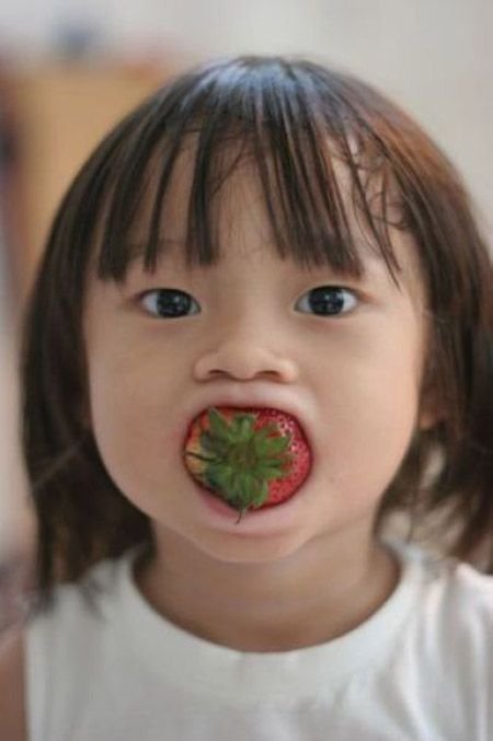 asian baby eating strawberry