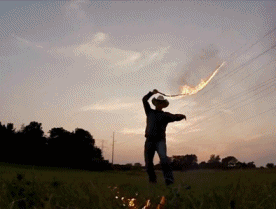 gifs - cowboy in a field with a whip and fire