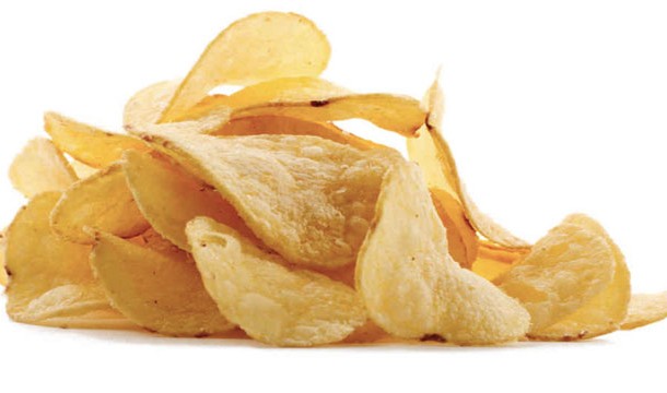 Place the chips on a towel in the microwave and heat them up a bit. The towel will absorb the moisture and the chips will regain their crunch.