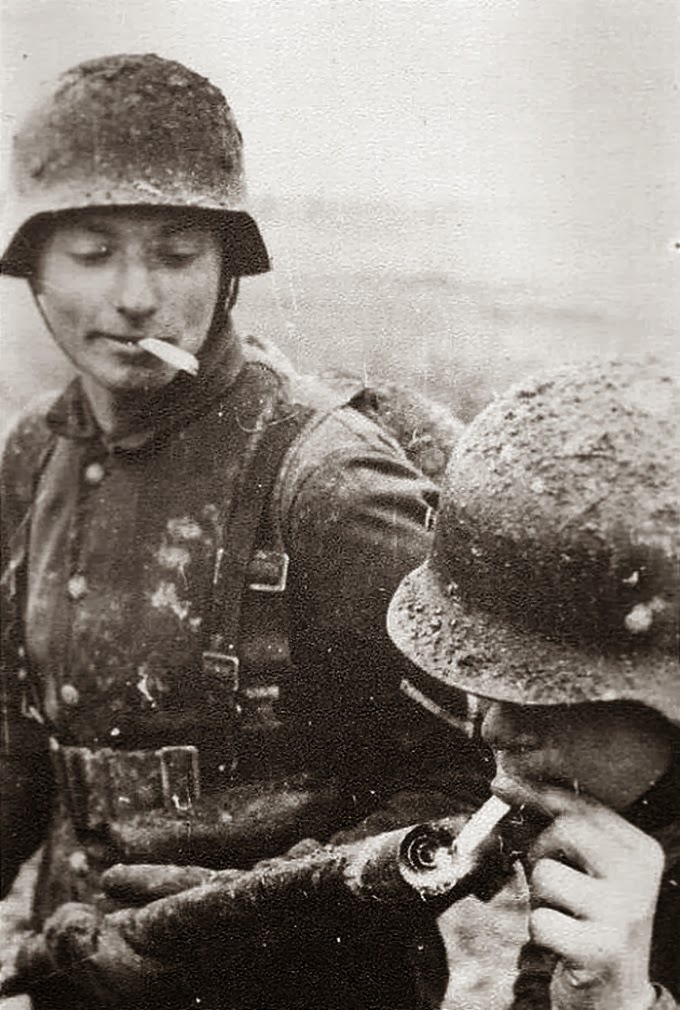 German soldier lights his cigarette with a flame thrower, 1940's.