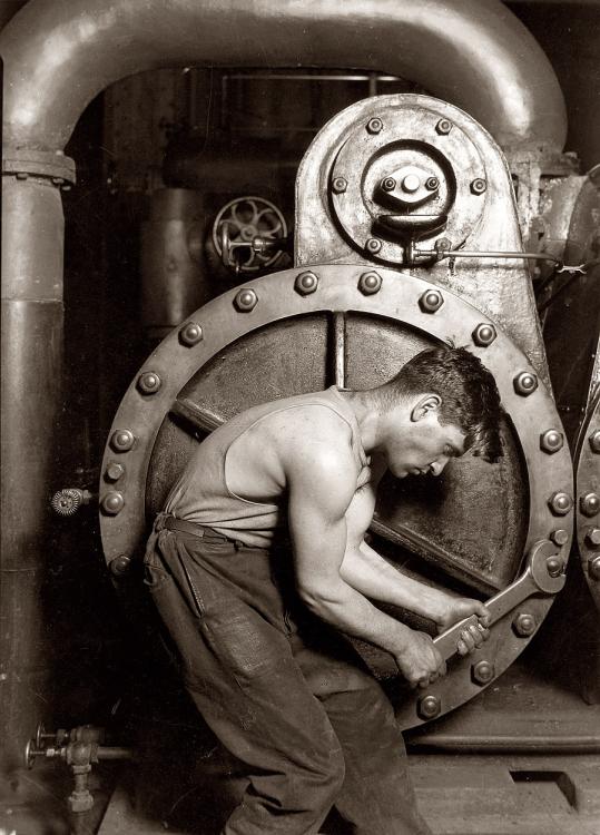 Man mending a steam pump, 1925.