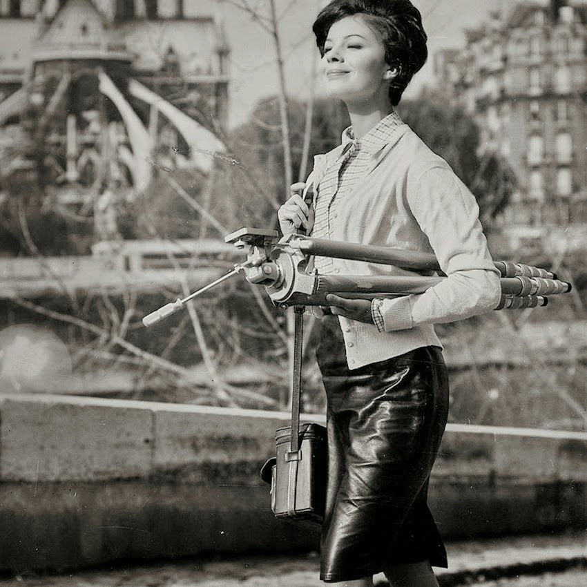 Lady photographer with a heavy tripod, ca. 1960s.