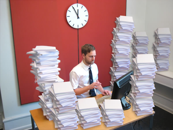 The stack strategy. Don't only keep a pile of scattered documents on your desk. Be sure to build a few towers made out of instruction manuals. Not only
do they cover a lot of things you'd like to hide, it also gives you the "this guy knows what he's doing" look.