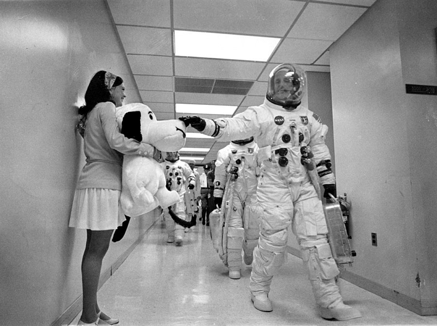 The Apollo 10 crew pets Snoopy on the nose as they walk towards their 

spacecraft the morning of launch. May 18, 1969.