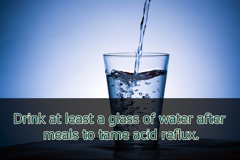 pouring water into a glass - Drink at least a glass of water after meals to tame acid reflux.