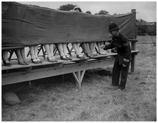 A policeman judges an ankle competition in England (1930).