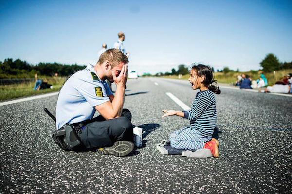danish cop playing with syrian refugee