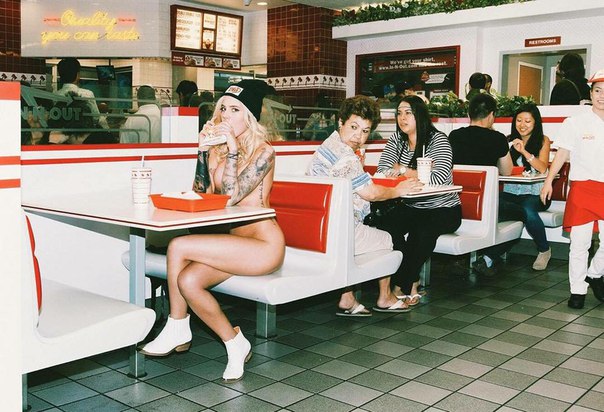 Tattooed girl spotted eating a hamburger in public only wearing 

shoes and a hat.