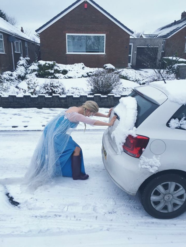 girl pushing car in snow