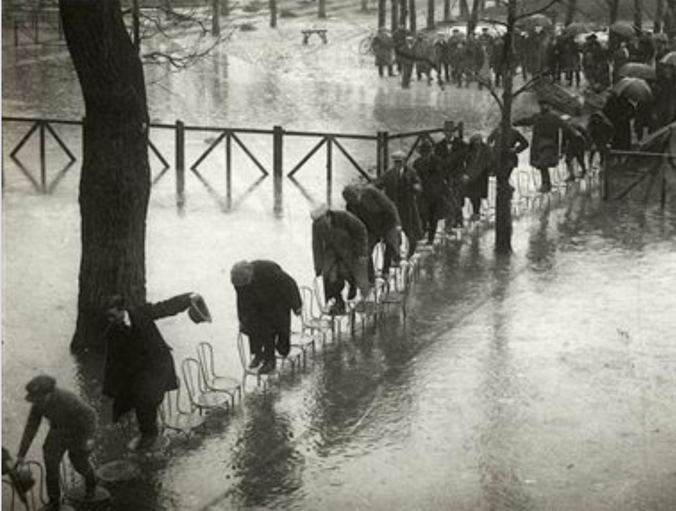 People in Paris avoid getting wet in the flood by stepping on a series of 

chairs in 1924.