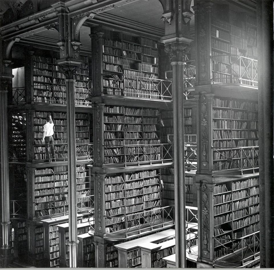 A man browsing for books in Cincinnati's cavernous old main library. The 

library was demolished in 1955.