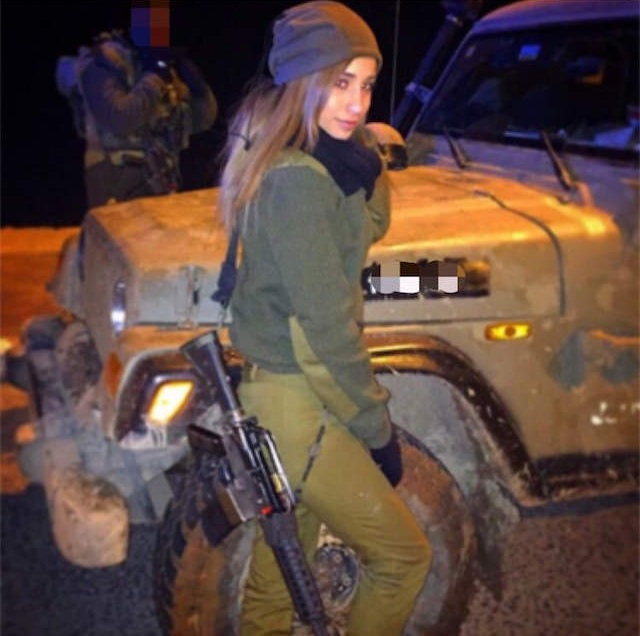 Kim Mellibovsky wearing on-duty uniform in the IDF standing with m-16 assault rifle next to an army jeep.