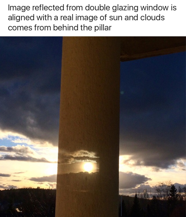 cool sky - Image reflected from double glazing window is aligned with a real image of sun and clouds comes from behind the pillar