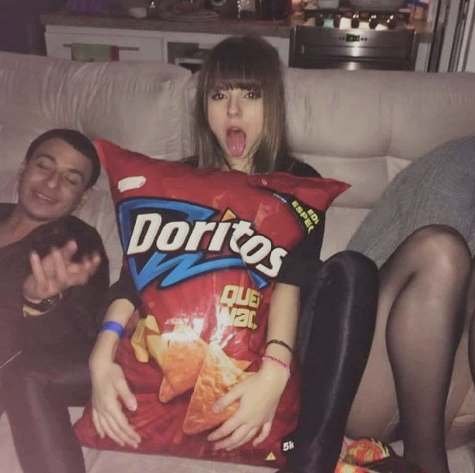 Funny picture of a girl holding an enormous Doritos bag.