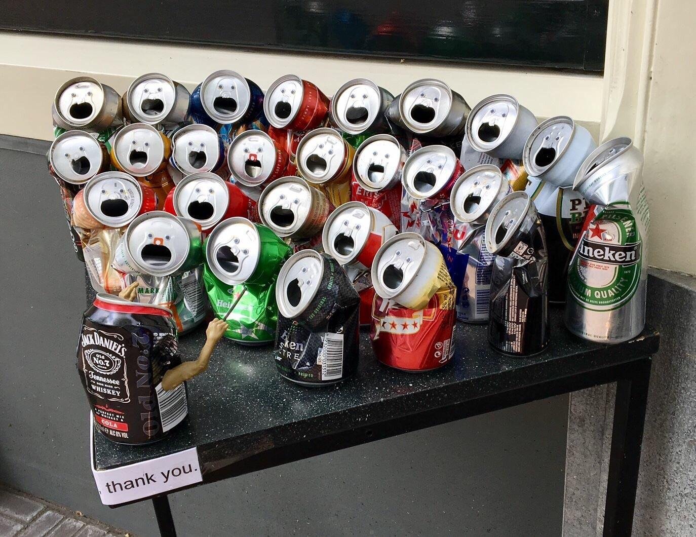 Cans crushed slightly and arranged to looks like a class being taught.