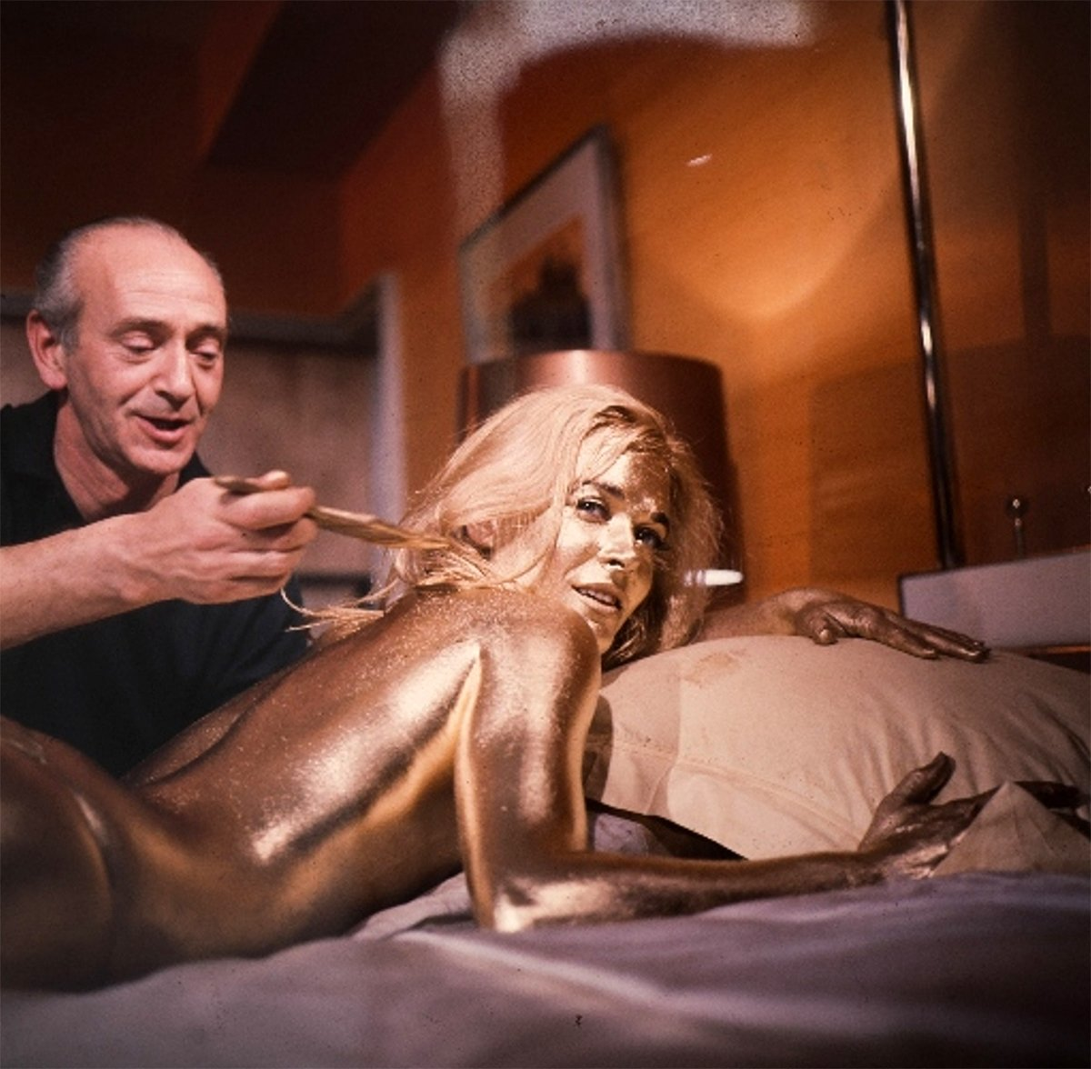 Behind the scenes pic from James Bond Goldfinger in which gold is being applied to the woman on the bed.