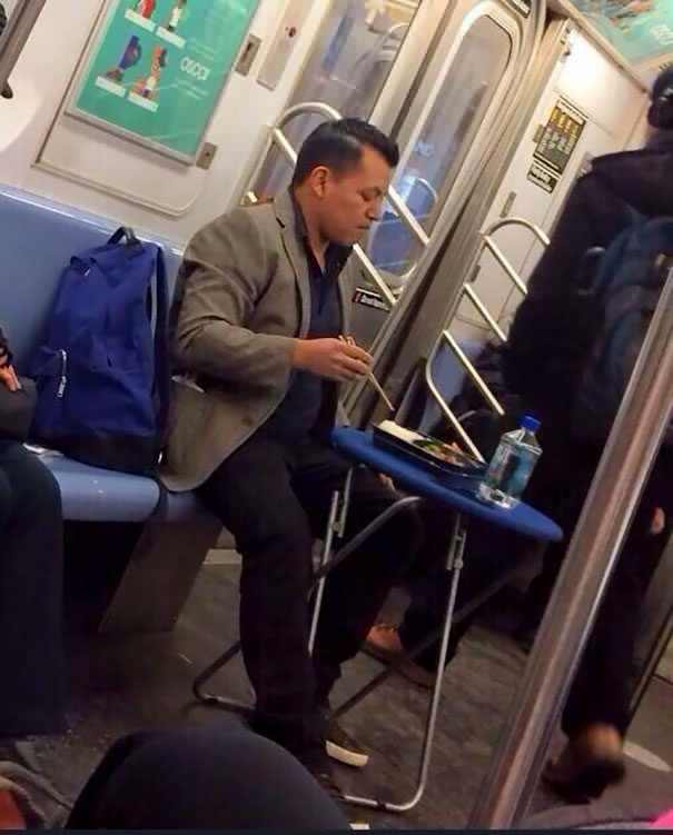 funny picture of man having a meal on a folding table on the subway