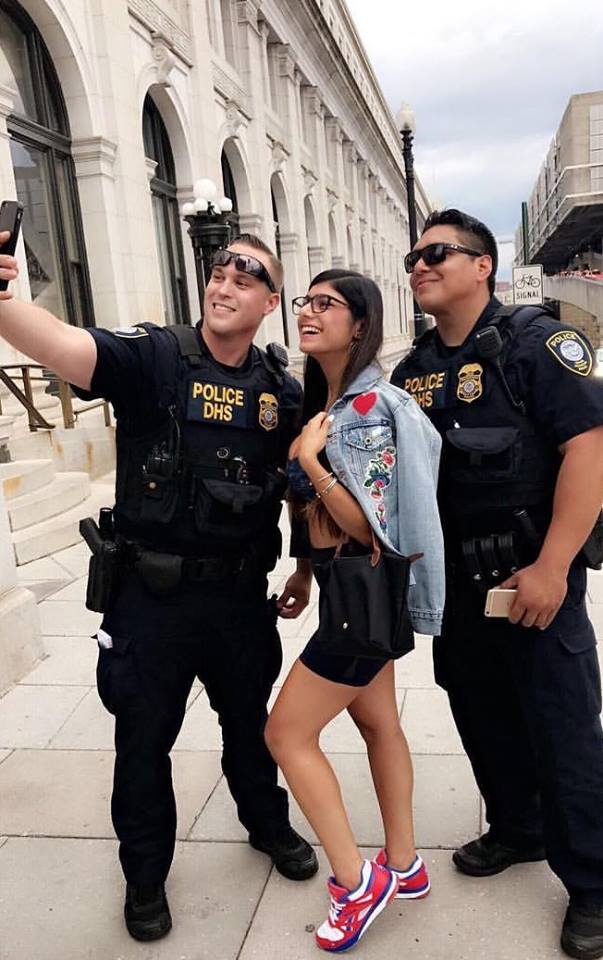 Mia Khalifa posing for a pic with some police officers.