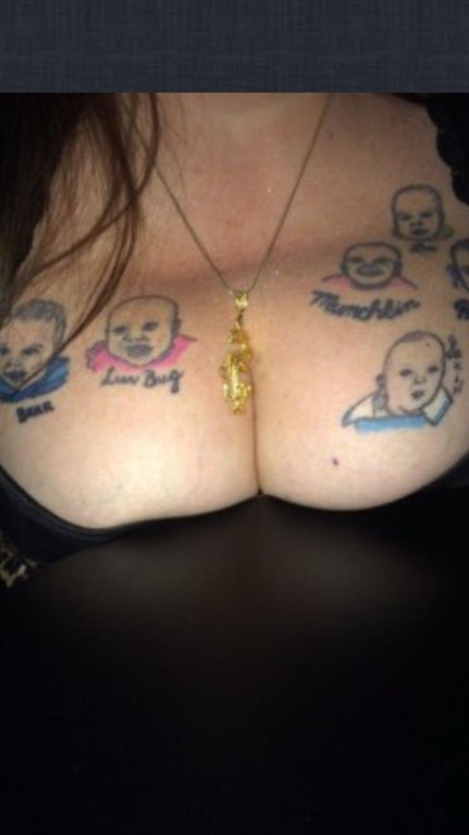 Strange bald men on a woman't bust tattoo