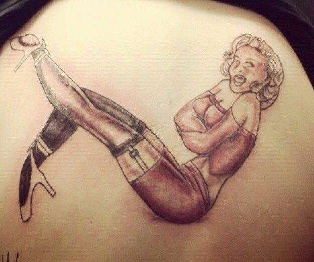 Bad Marilyn Monroe tattoo on a girls shoulder.