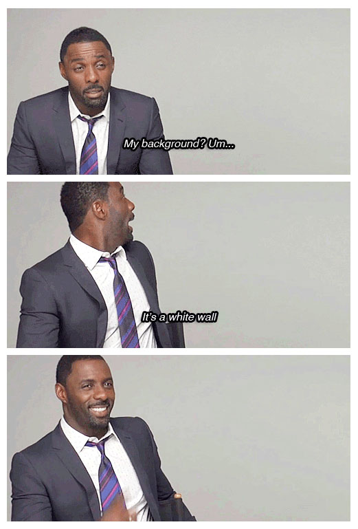 Idris Elba cracking a joke that his background is a white wall.