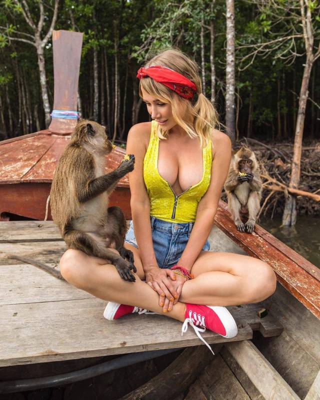 Monkey playing with woman in yellow tank top