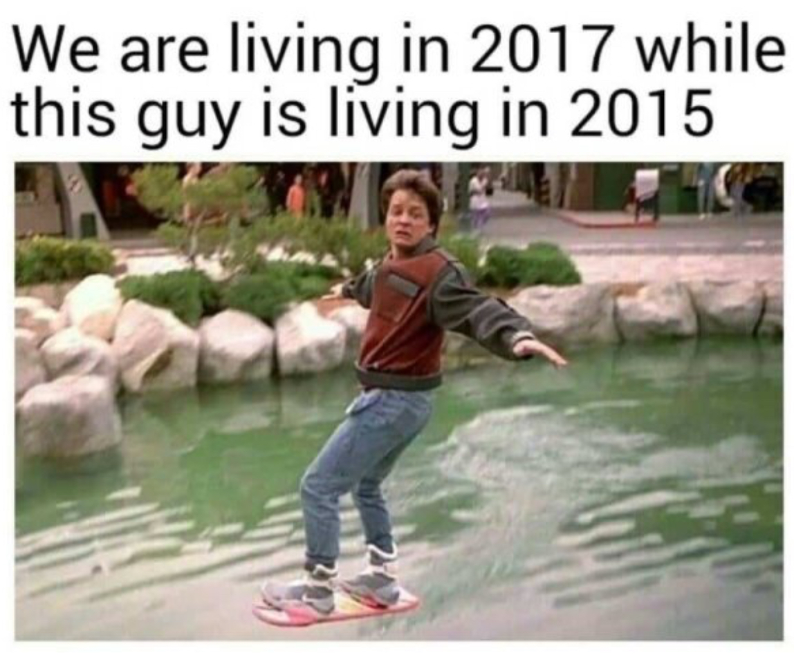 Ironic meme of us all living in 2017 while a younger Marty McFly played by Michael J. Fox is hover-boarding across a pond and living in 2015