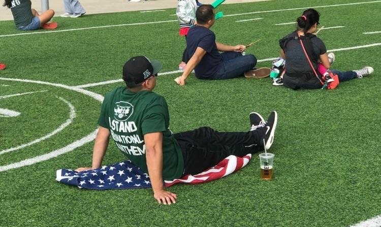 jets fan sitting on flag - Ng Stand Utions