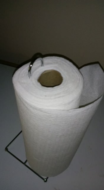 infuriating image of a paper towel roll mounted wrongly wit the metal axis jammed into the spool of paper that is the roll
