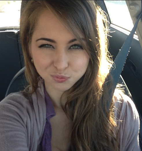 Riley Reid taking a selfie in a car with a seatbelt.