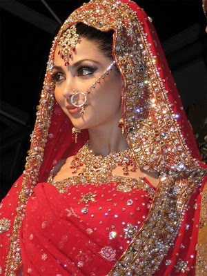 Indian wedding garb is among the most elaborate in the world. Red is the traditional color, as white is reserved for funerals in this culture. Bindhi, henna tattoos, and detailed piercings with connecting chainwear adds to the dramatic effect.
